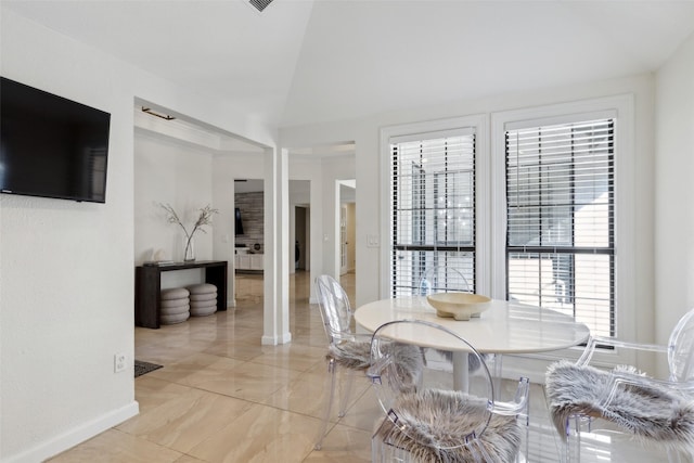 dining room with vaulted ceiling and baseboards