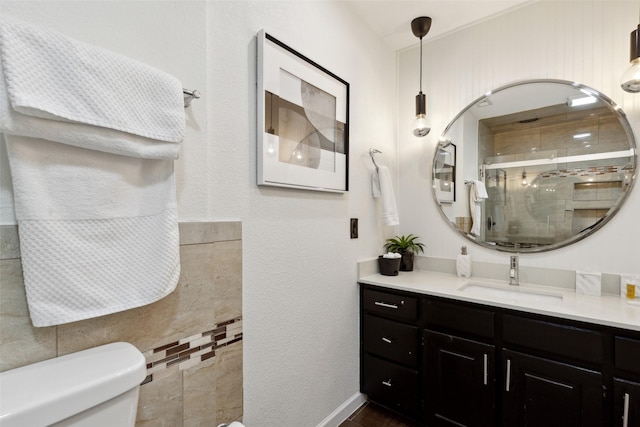 bathroom with a stall shower, vanity, and toilet