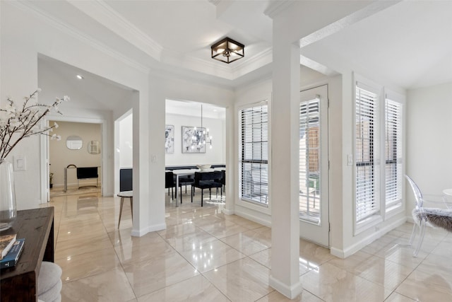 interior space featuring crown molding, a notable chandelier, and baseboards