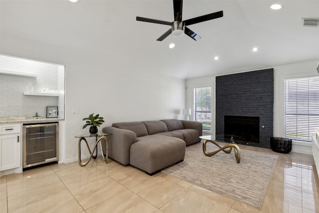 living room with wine cooler, a fireplace, recessed lighting, visible vents, and a bar