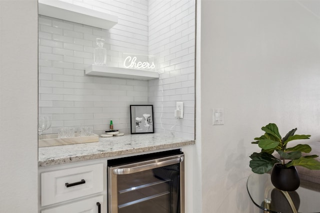 bar featuring beverage cooler, backsplash, and a dry bar