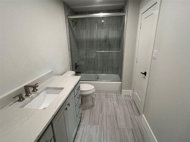 3244 Crites St, Richland Hills, TX 76118 - full bathroom featuring toilet, vanity, enclosed tub / shower combo, baseboards, and wood tiled floors