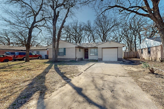 view of front of house featuring a garage, concrete driveway, brick siding, and fence