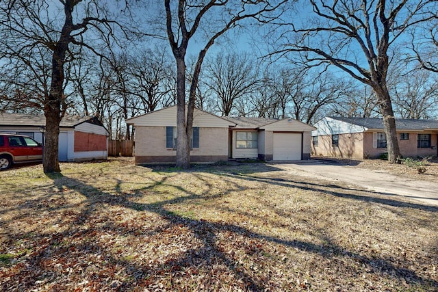 ranch-style home featuring a garage, driveway, brick siding, and a front lawn