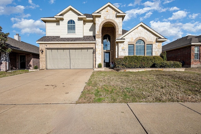 traditional-style home featuring brick siding, an attached garage, stone siding, driveway, and a front lawn