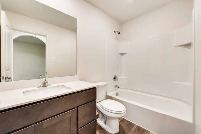 bathroom featuring washtub / shower combination, vanity, toilet, and wood finished floors