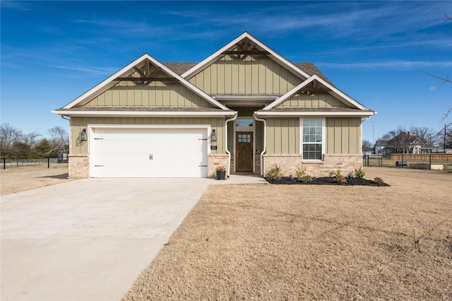 craftsman inspired home featuring brick siding, an attached garage, board and batten siding, fence, and driveway