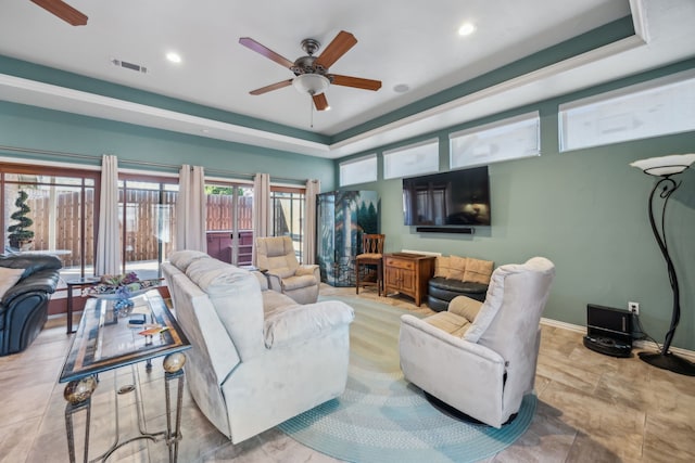 living room featuring a tray ceiling, recessed lighting, visible vents, ceiling fan, and baseboards