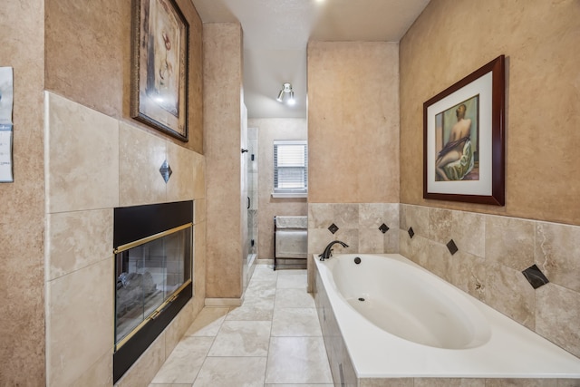 bathroom with tile patterned flooring, a garden tub, a fireplace, and a shower stall