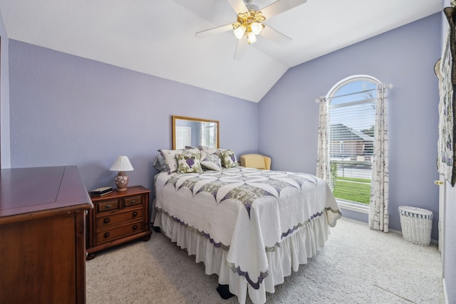 bedroom featuring light carpet, vaulted ceiling, and a ceiling fan