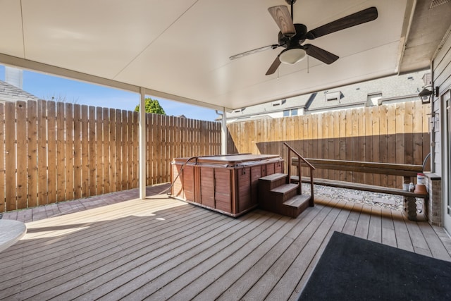 deck featuring a hot tub, fence, and a ceiling fan