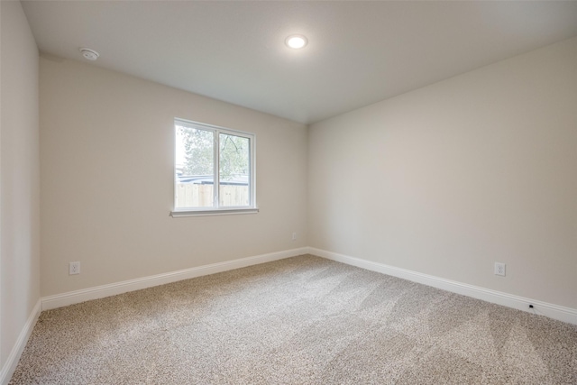 unfurnished room featuring carpet floors and baseboards