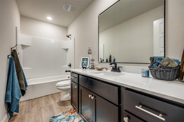 bathroom featuring visible vents, toilet, vanity, wood finished floors, and  shower combination