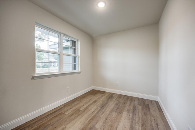 unfurnished room with baseboards and wood finished floors