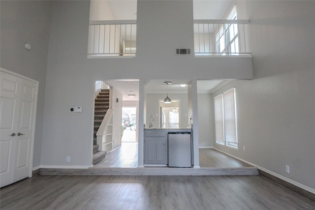 foyer with visible vents, stairway, a wealth of natural light, and wood finished floors