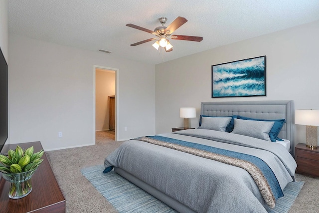 carpeted bedroom featuring a ceiling fan, visible vents, a textured ceiling, and baseboards