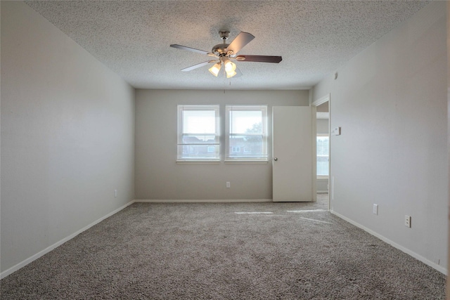 unfurnished room featuring a textured ceiling, carpet floors, a ceiling fan, and baseboards