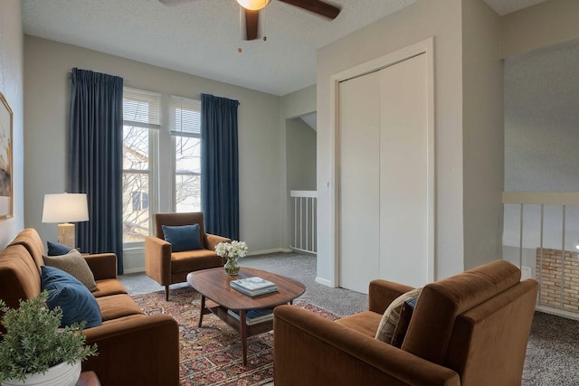 carpeted living area with a textured ceiling, a ceiling fan, and baseboards