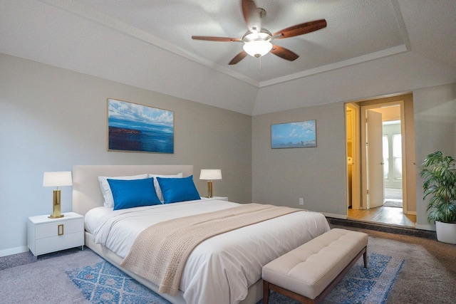 bedroom with a tray ceiling, carpet flooring, a ceiling fan, and baseboards