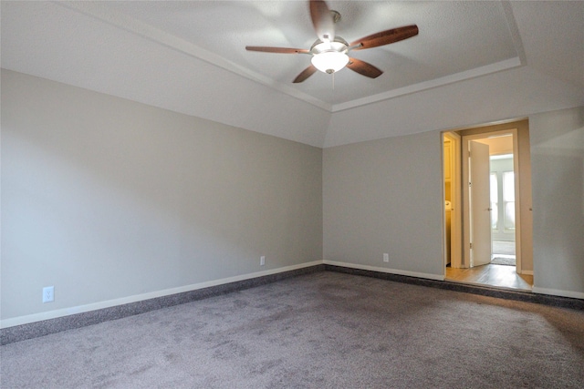 unfurnished room featuring ceiling fan, vaulted ceiling, carpet flooring, and baseboards