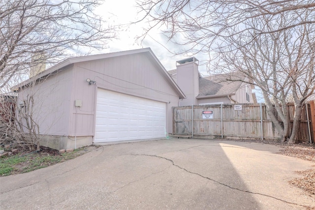 garage with driveway and fence