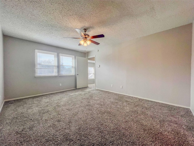 unfurnished room featuring carpet, ceiling fan, a textured ceiling, and baseboards