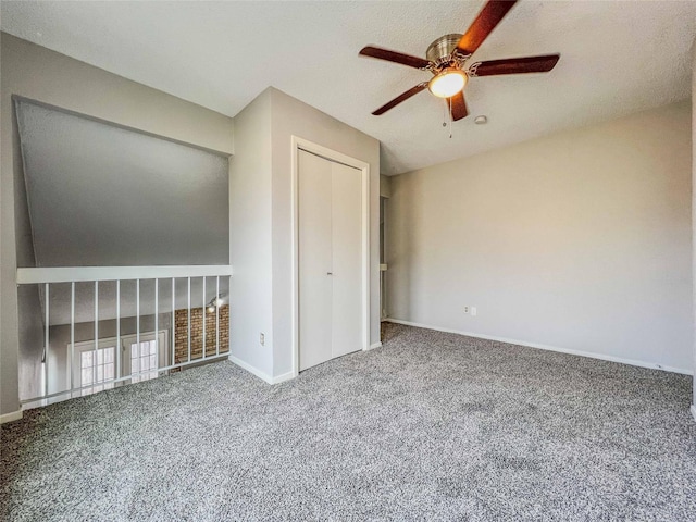 carpeted empty room featuring a ceiling fan and baseboards