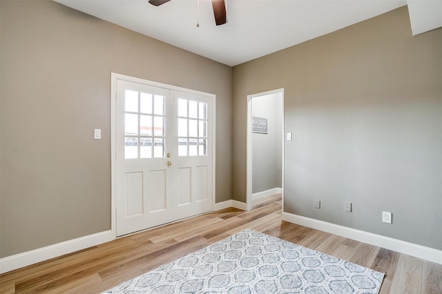 doorway with ceiling fan, baseboards, and wood finished floors