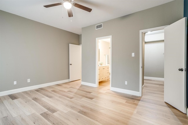 unfurnished bedroom featuring light wood finished floors, ceiling fan, baseboards, and ensuite bathroom