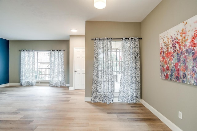 unfurnished dining area featuring baseboards and wood finished floors