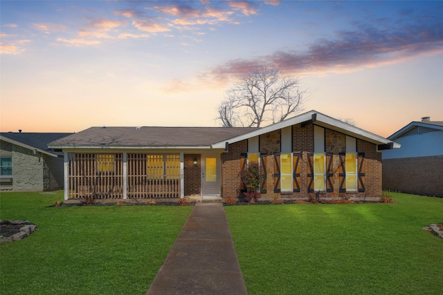 mid-century home featuring brick siding and a front yard