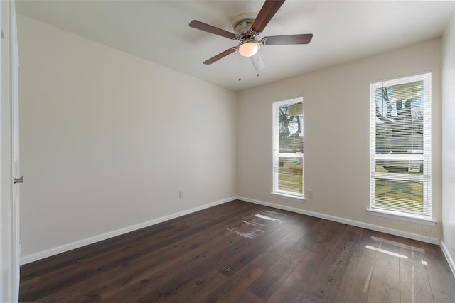 empty room with a ceiling fan, dark wood-style flooring, and baseboards