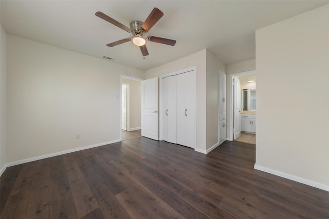 unfurnished bedroom with visible vents, baseboards, ceiling fan, dark wood-style flooring, and a closet