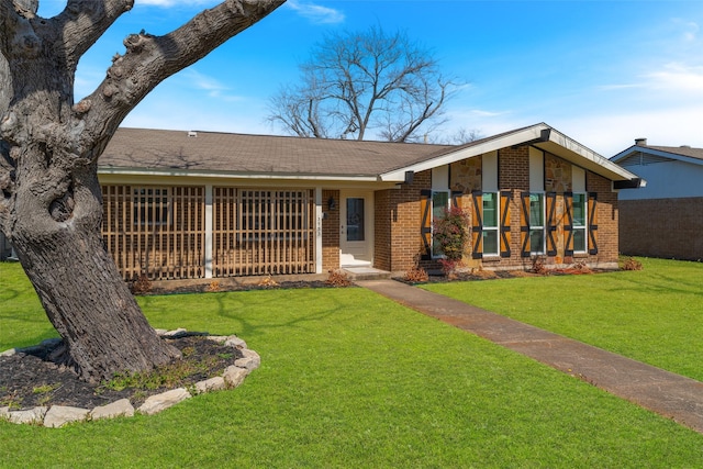 mid-century inspired home with a front yard and brick siding