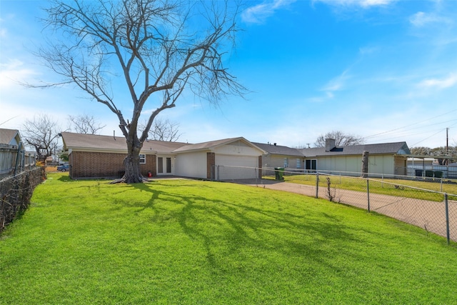 view of front facade with an attached garage, fence private yard, decorative driveway, a front yard, and brick siding