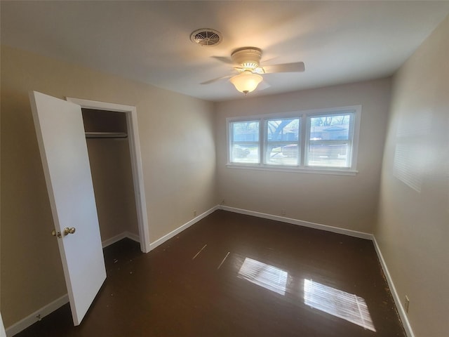 unfurnished bedroom featuring ceiling fan, a closet, visible vents, and baseboards