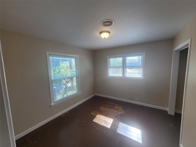 spare room with a healthy amount of sunlight, visible vents, and baseboards