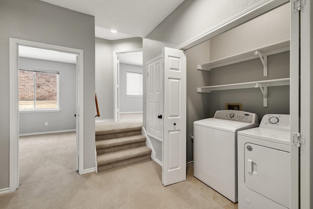 laundry room featuring laundry area, light colored carpet, baseboards, and washing machine and clothes dryer