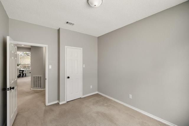 unfurnished bedroom with baseboards, visible vents, and light colored carpet