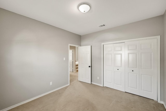 unfurnished bedroom with baseboards, a closet, visible vents, and carpet flooring