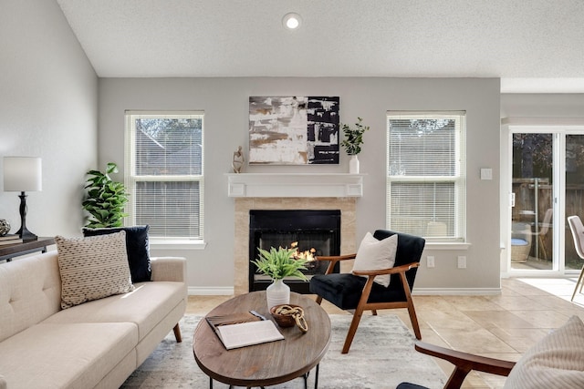 tiled living room with a premium fireplace, baseboards, and a textured ceiling