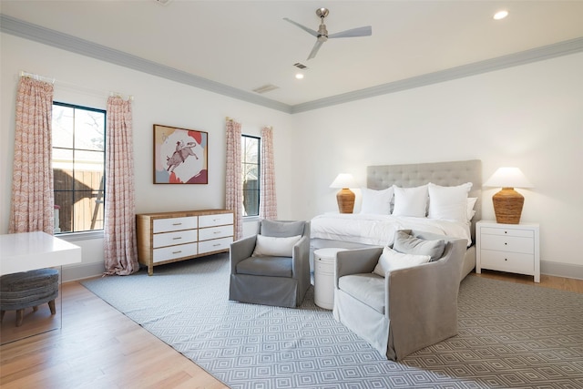 bedroom featuring multiple windows, wood finished floors, and crown molding
