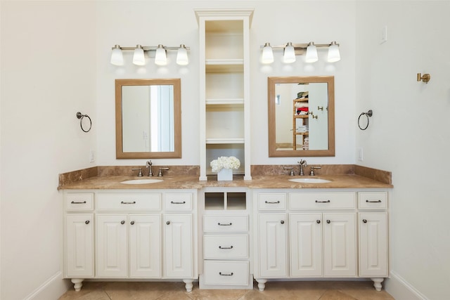 full bathroom with double vanity, tile patterned flooring, baseboards, and a sink