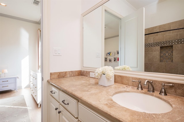 bathroom featuring ornamental molding, vanity, and visible vents
