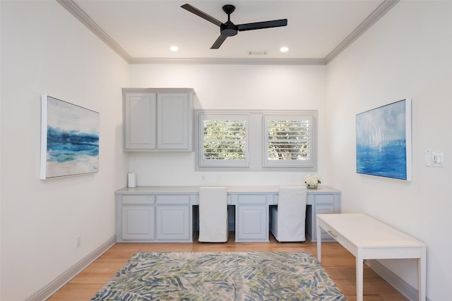 office featuring light wood-style floors, visible vents, crown molding, and built in study area