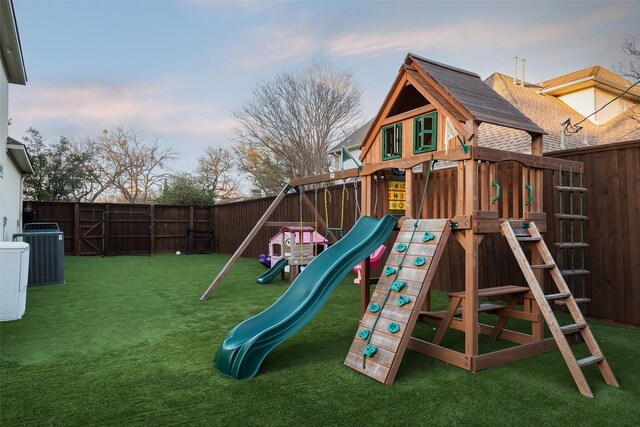 view of jungle gym featuring a fenced backyard, a lawn, and central AC unit
