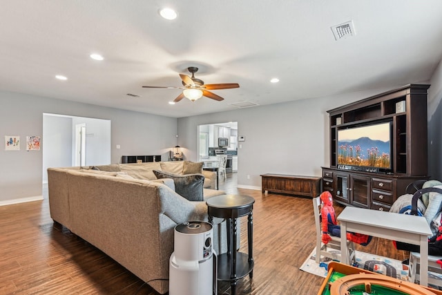 living room featuring baseboards, visible vents, ceiling fan, wood finished floors, and recessed lighting