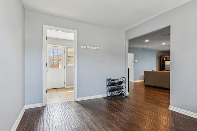 unfurnished room featuring baseboards, wood finished floors, and recessed lighting