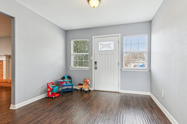 foyer featuring baseboards and wood finished floors