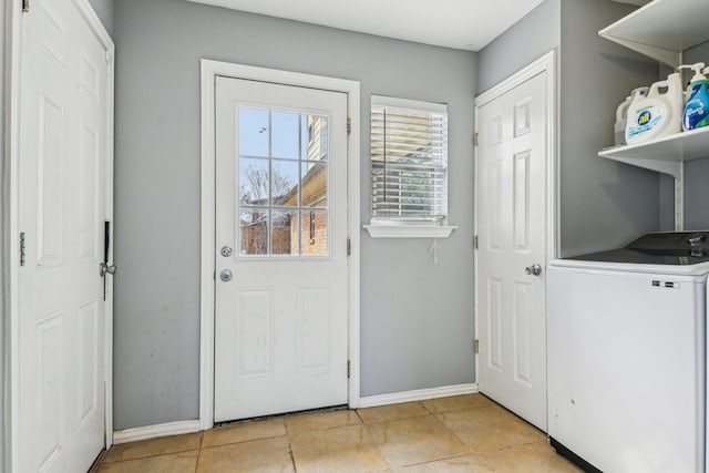 doorway with baseboards and washer / clothes dryer